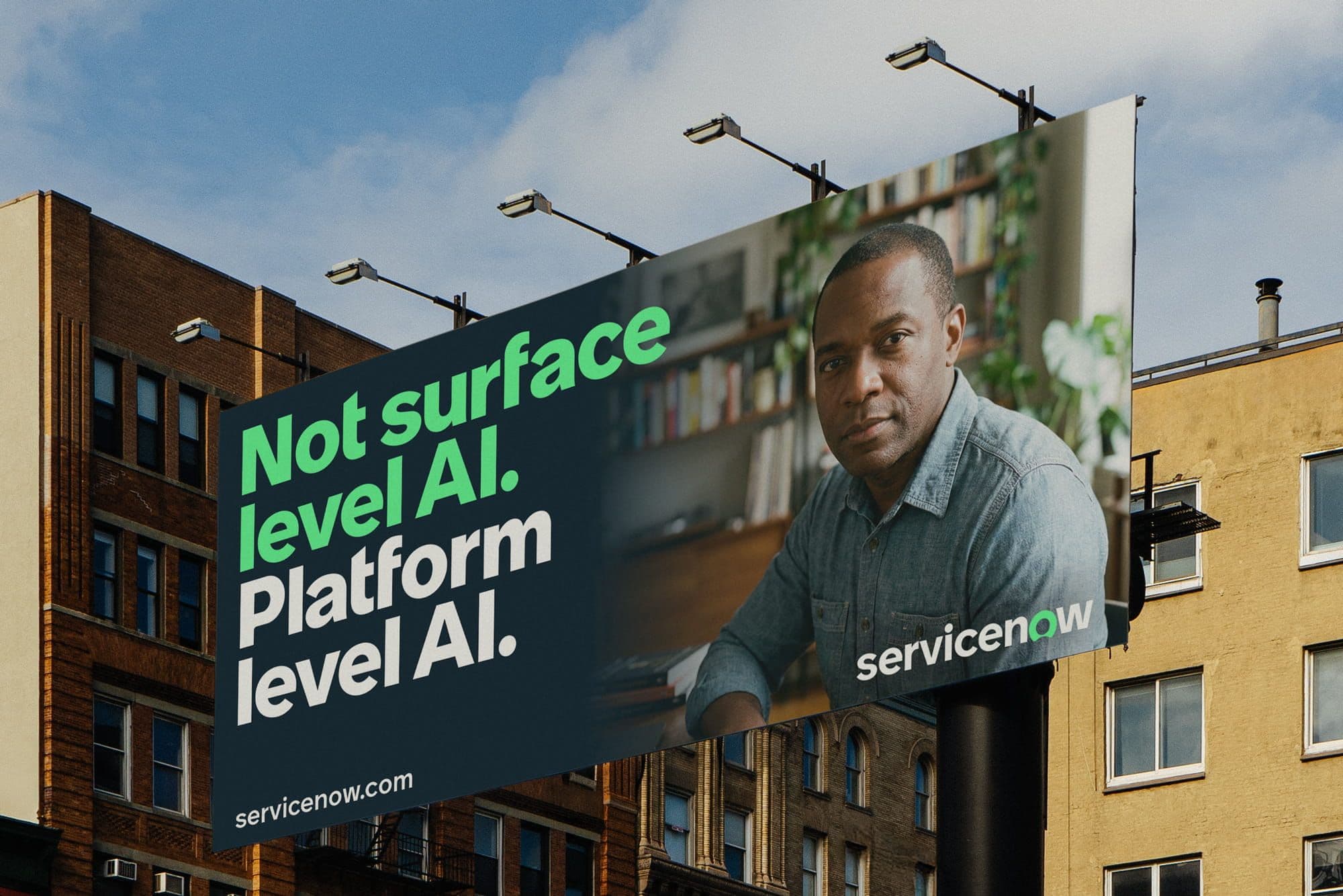Billboard featuring a person in a denim shirt with text "Not surface level AI. Platform level AI." Promotes ServiceNow against an urban backdrop.
